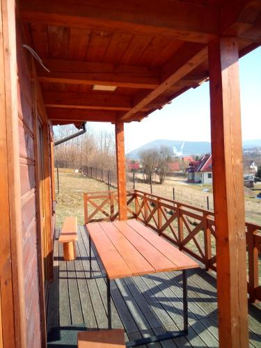 a wooden bench on the porch of a house at Słoneczne Chaty Kasina Wielka in Kasina Wielka