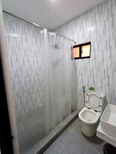 a bathroom with a toilet and a shower at Welcome to Our Farm House in Del Rosario
