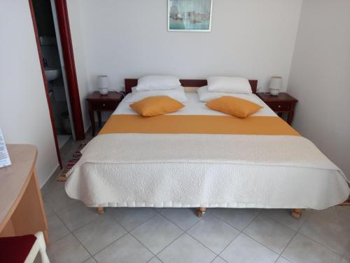 a bedroom with a bed with two pillows on it at Rooms Radic in Dubrovnik
