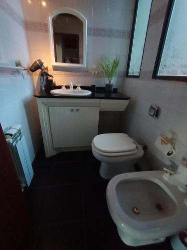 a bathroom with a white toilet and a sink at hermosa casa a una cuadra del lago in San Carlos de Bariloche
