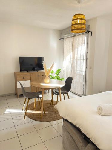 une salle à manger avec une table et des chaises et une télévision dans l'établissement Studio, climatisation, Terrasse, parking, 1 min Tramway, à Nice