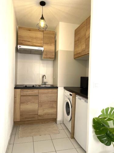 une cuisine avec un évier et une machine à laver dans l'établissement Studio, climatisation, Terrasse, parking, 1 min Tramway, à Nice