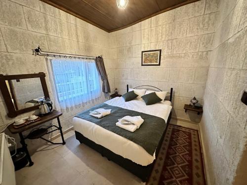 a bedroom with a bed with towels on it at Turan Cappadocia Cave in Goreme