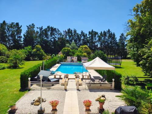 - une piscine dans une cour avec une tente dans l'établissement La Batisse, à Saint-Laurent