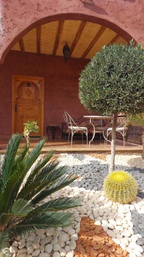 a patio with a table and chairs and a tree at Chez Mamouchthka in Ourika