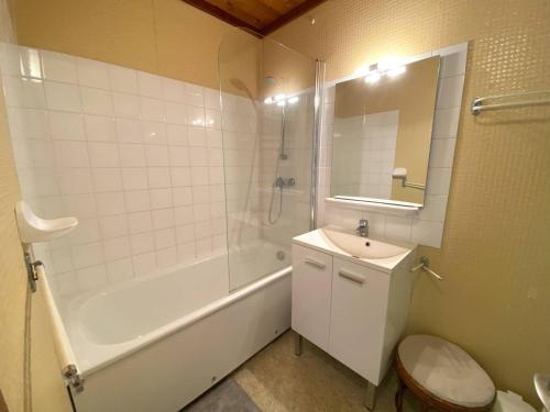 une salle de bain avec une baignoire, des toilettes et un lavabo dans l'établissement Appartement à 400m de la plage de Trestraou avec terrasse et parking - FR-1-368-329, à Perros-Guirec