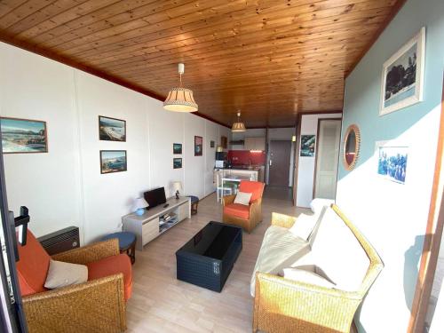 un salon avec un canapé et des chaises dans l'établissement Appartement à 400m de la plage de Trestraou avec terrasse et parking - FR-1-368-329, à Perros-Guirec