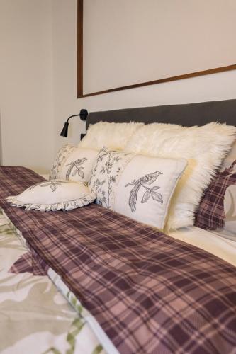 a bed with pillows on top of it at Appartamento Alpino Cles in Cles
