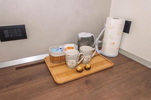 a wooden tray with four cups on a table at Appartamento Alpino Cles in Cles
