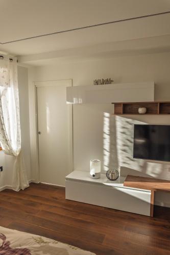 a living room with a television and a table at Appartamento Alpino Cles in Cles