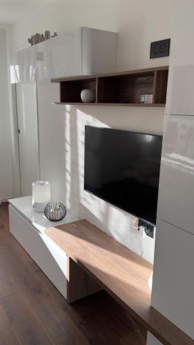 a living room with a flat screen tv on a counter at Appartamento Alpino Cles in Cles