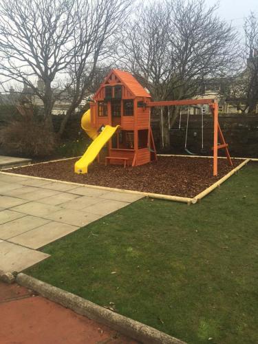 a small playground with a slide in a yard at Seafield Arms Hotel in Whitehills