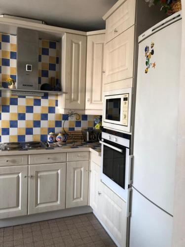 een keuken met witte kasten en een witte koelkast bij Proximité Palais des Festivals in Cannes