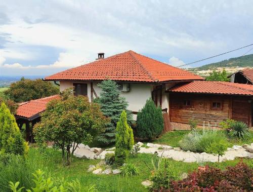 a house with an orange tiled roof in a garden at Etno kompleks Orahovac - Vila Paun in Vrbica