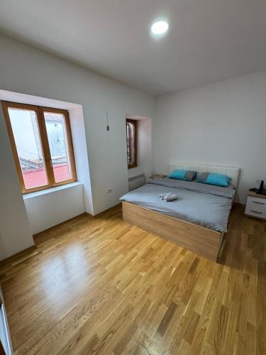 a bedroom with a bed and a wooden floor at Old House Bozovic in Nikšić