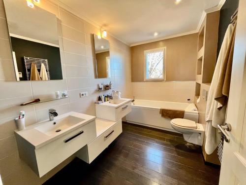 une salle de bain avec deux lavabos et une baignoire et des toilettes dans l'établissement Villa Christiane, à Malaucène