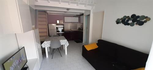 un petit salon avec une table et un canapé dans l'établissement La Maison Jeanne, Portiragnes Plage, à Portiragnes