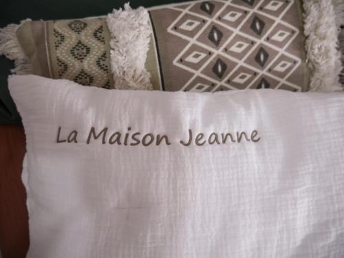 un oreiller blanc avec les mots la masonianeiane sur lui dans l'établissement La Maison Jeanne, Portiragnes Plage, à Portiragnes