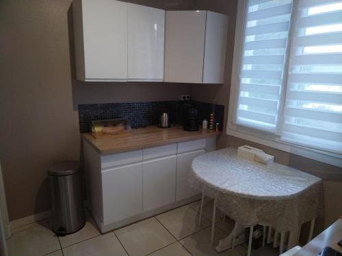 una cocina con armarios blancos y una mesa pequeña. en House, en Blois