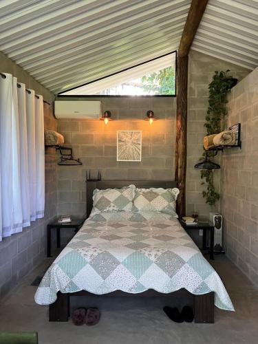 a bedroom with a large bed with a window at Cabana para casal no Vale do Cuiabá Itaipava in Araras Petropolis
