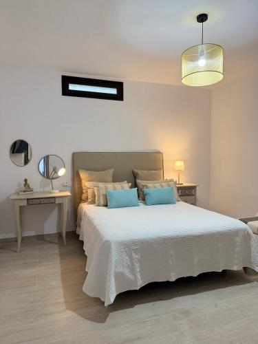 a bedroom with a large white bed with blue pillows at Casa del Sol B in Arrieta