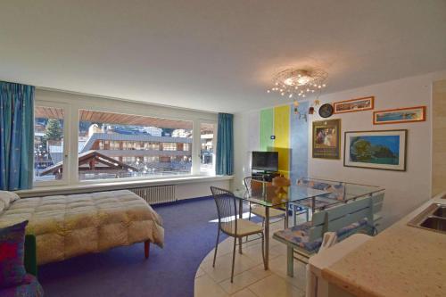 Un dormitorio con una cama y una mesa de cristal. en RAINALTER Studio 14A Centrale, en Madonna di Campiglio