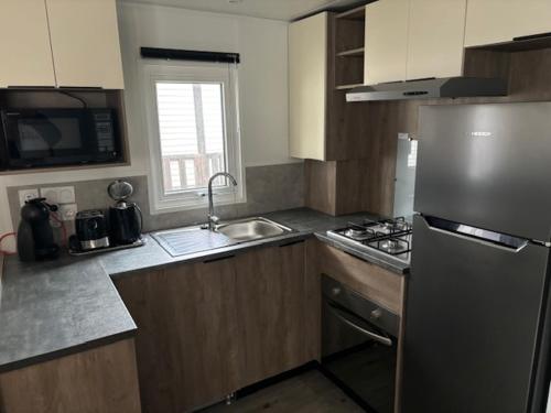 une cuisine avec un réfrigérateur en acier inoxydable et un évier dans l'établissement Bora Bora 6-8 personnes, à Saint-Jean-de-Monts