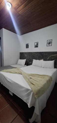 a bedroom with two beds in a room at Pousada das Tartarugas in Rio das Ostras