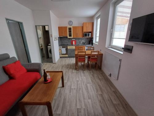 a living room with a red couch and a table at Apartmán v centru Zlína s parkováním u domu in Zlín