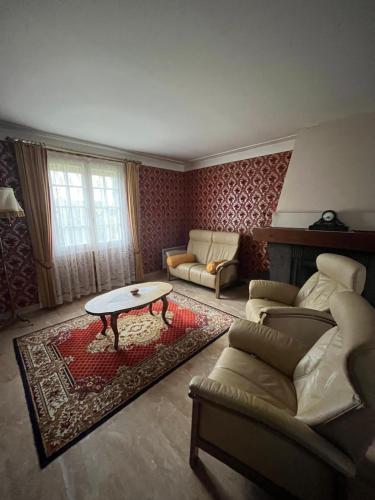 un salon avec un canapé et une table dans l'établissement Spacieuse maison de village, à Luché-Pringé