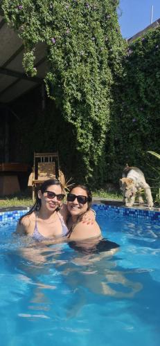 two women in a swimming pool with a dog at Casa Cipres in Laredo Hacienda