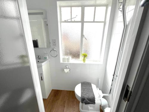 a small bathroom with a toilet and a window at Large Family-Friendly 2BD Glastonbury Retreat, Sleeps 5 in Glastonbury