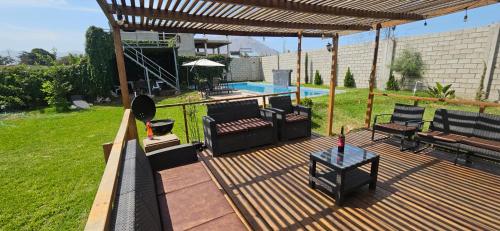 a wooden deck with benches and a swimming pool at Casa Cipres in Laredo Hacienda