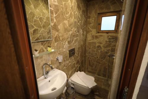 a bathroom with a sink and a toilet at Turan Cappadocia Cave in Goreme