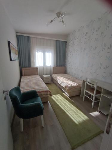 a bedroom with two beds and a chair and a table at Dubrava 112 in Dobra Voda