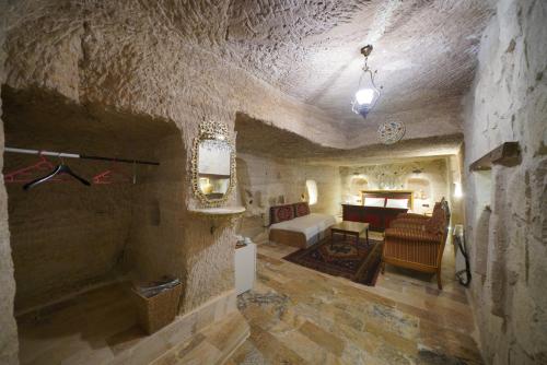 a living room with a couch and a bed in a room at Turan Cappadocia Cave in Goreme