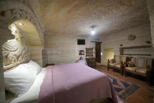 a bedroom with a bed and a couch in a room at Turan Cappadocia Cave in Goreme