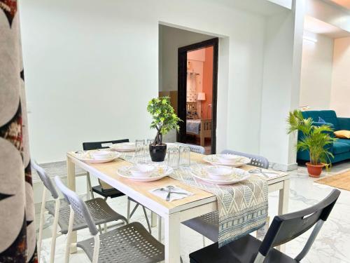 a dining room with a white table and chairs at Cityscape Comfort - Stylish 3BHK Central Getaway in Hyderabad