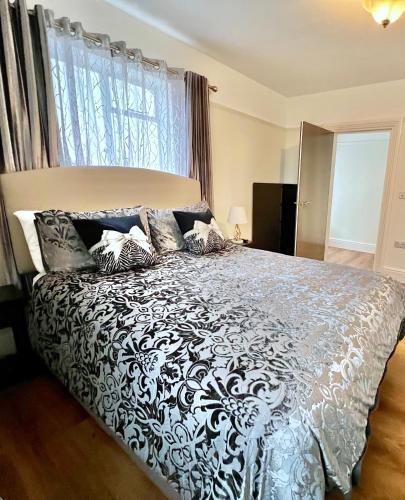 a bedroom with a black and white bed with a window at Large Family-Friendly 2BD Glastonbury Retreat, Sleeps 5 in Glastonbury