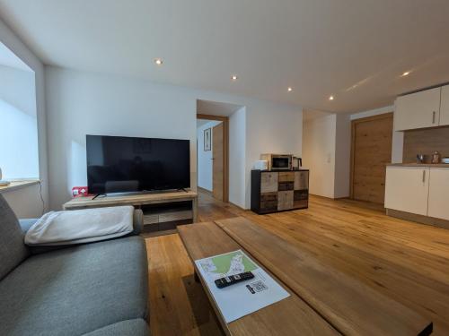 a living room with a couch and a flat screen tv at Ferienwohnung Gurgltal in Nassereith