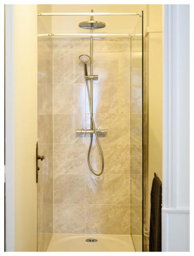 une douche avec une porte vitrée dans une salle de bain dans l'établissement Classic retro vibe 15 min from Paris, à Choisy-le-Roi