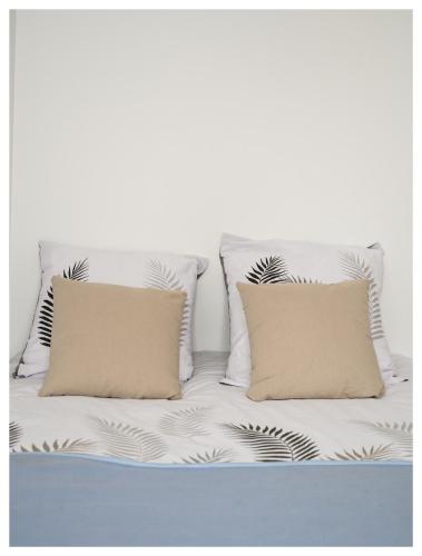 - un canapé blanc avec 2 oreillers dans l'établissement Classic retro vibe 15 min from Paris, à Choisy-le-Roi