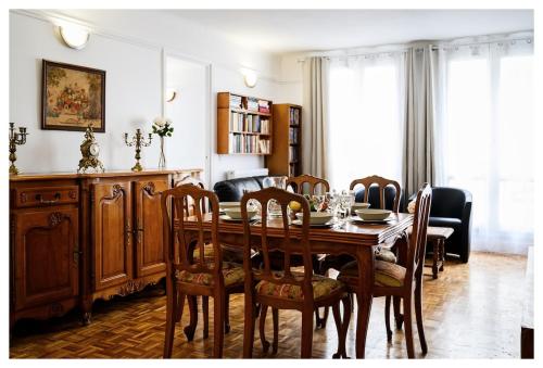 une salle à manger avec une table et des chaises en bois dans l'établissement Classic retro vibe 15 min from Paris, à Choisy-le-Roi