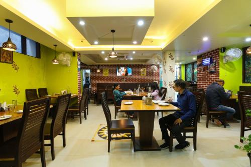people sitting at a table in a restaurant at Airport Hotel Grand in New Delhi