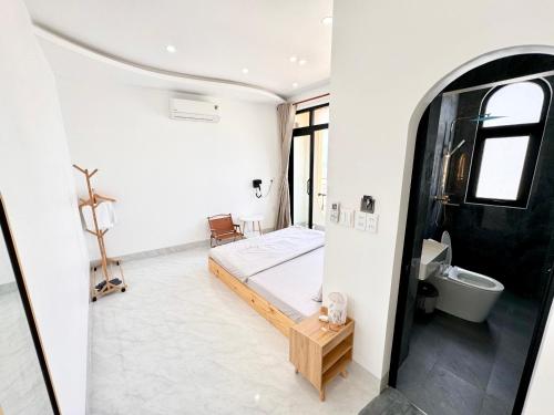 a white room with a bed and a bathroom at Dream House - Homestay - Đảo Phú Quý in Cù Lao Thu