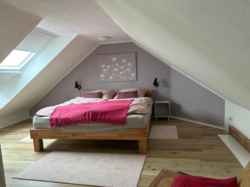 a bedroom with a bed with pink sheets on it at Ferienwohnung Harzglueck auf 2 Etagen mit grossem SW-Balkon in Hohegeiß