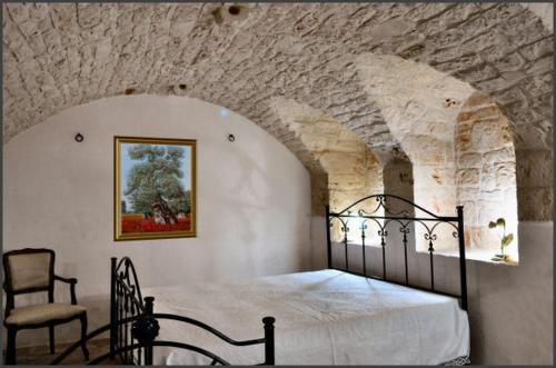 a bedroom with a bed in a stone wall at Masseria Costanza in Putignano