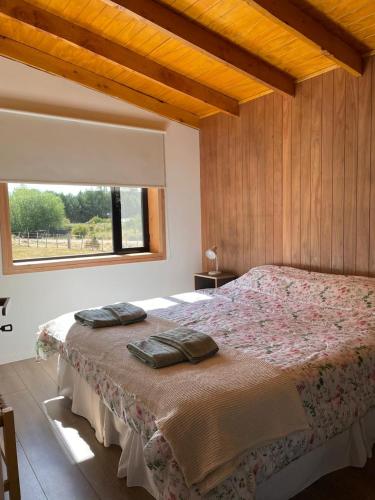 a bedroom with a bed with two pillows on it at Cabaña Lilacho in Cholila