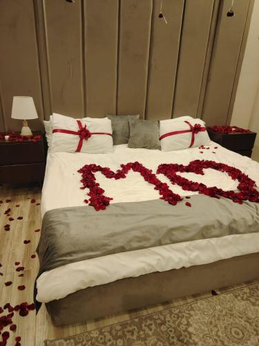 a bed with a heart made out of red flowers at أجنحة دارك للشقق المخدومة - Ajnihat Dark Serviced Apartments in Ad Dawādimī