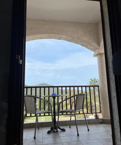 a balcony with two chairs and a table and a view at residence u filipaghju in Galeria
